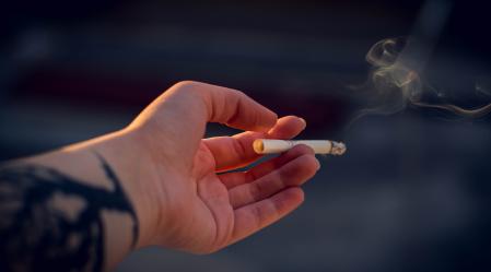 close up photography of a person holding cigarette 798124
